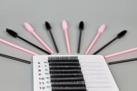 A tablet with false eyelashes and brushes on a black background. Stock Photos