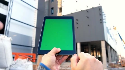 Tablet with green screen against the backdrop of a building under construction. Stock Footage 153662233