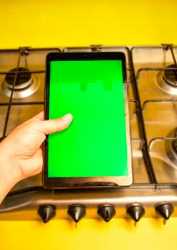Tablet with green screen with the background of a kitchen. Stock Photos