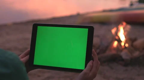 Tablet with Green Screen on Beach during a Sunset and Campfire. Stock Footage 63348490