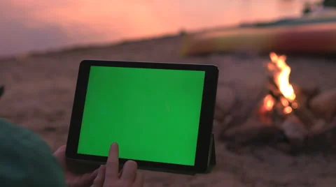 Tablet with Green Screen on Beach during a Sunset and Campfire. Stock Footage 63348554
