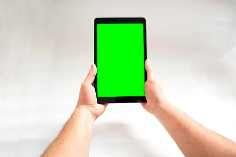 Tablet with green screen fastened with two hands on white background. Stock Photos