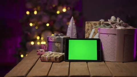 Tablet with green screen, gift box, Christmas tree. Happy New Year 2022 Stock Footage 165698893