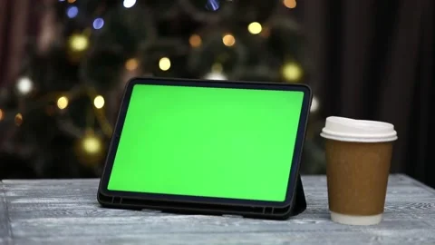 Tablet with green screen in hands next to glass of coffee Stock Footage 226188741