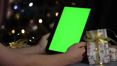 Tablet with green screen in hands next to gifts on christmas background Video stock 226188743