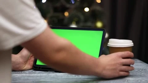 Tablet with green screen in hands next to glass of coffee Stock Footage 236599005