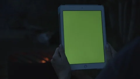 Tablet green screen held in front of campfire at night, 4k Stock Footage 112897404