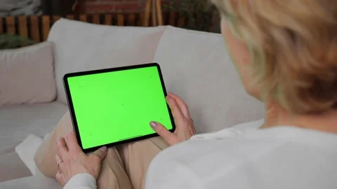 A tablet with a green screen for integrating media content held by a woman Stock Footage 233467941