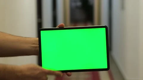 Tablet with green screen mock up close up, Blurred hotel corridor on background 库存影片 305448261
