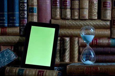 Tablet with green screen with old books in background Stock Photos