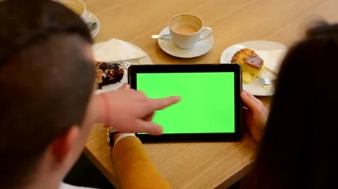 Tablet green screen - woman and man works on tablet in cafe - coffee and cake Stock Footage