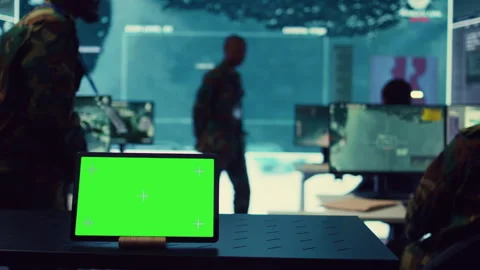 Tablet with greenscreen display running in a command post base of operations Stock Footage 276918559