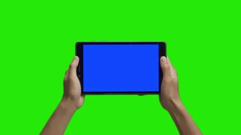 Tablet in the hand close up isolated at green background. Tablet screen is blue  Stock Footage 198296939