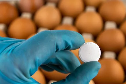 Tablet in the hand of a laboratory assistant in the background of a tray of e Stock Photos