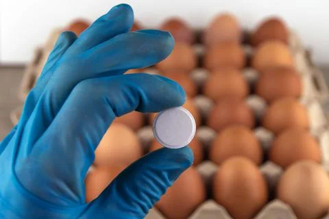 Tablet in the hand of a laboratory assistant in the background of a tray of e Stock Photos