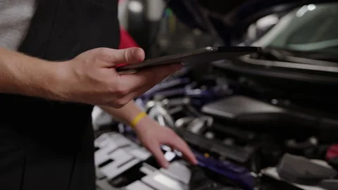 Tablet in the hands of mechanic during the preparation of an order before repair Stock Footage 253390962