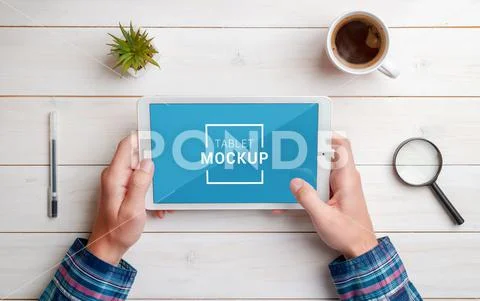 Tablet in hands mockup on work desk. Top view, flat lay composition. Close-up. W PSD-sjabloon