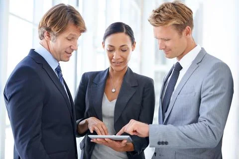 This tablet has incredible business functionality. Three businesspeople looking 写真素材
