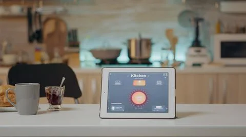 Tablet with intelligent software placed on table in kitchen with nobody in Stock Photos
