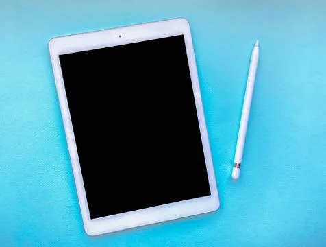 Tablet mock up on table with stylus isolated on blue background. Business con Stock Photos