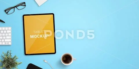 Tablet mockup on blue work desk. Top view, flat lay scene with up of coffee, key Template PSD
