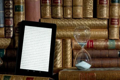 Tablet with old books in the background Stock Photos