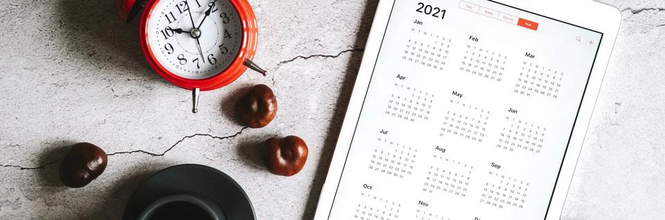 A tablet with an open calendar for 2021 year, a cup of coffee, chestnuts and  Stock Photos