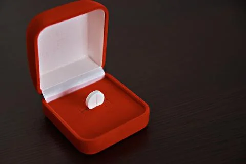 A tablet in an open red box. The topic of health care, treatment and preventi Stock Photos