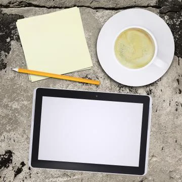 Tablet pc and coffee cup on old concrete surface Stock Illustration