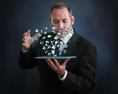 Tablet pc with cloud of application icons flying around Stock Photos