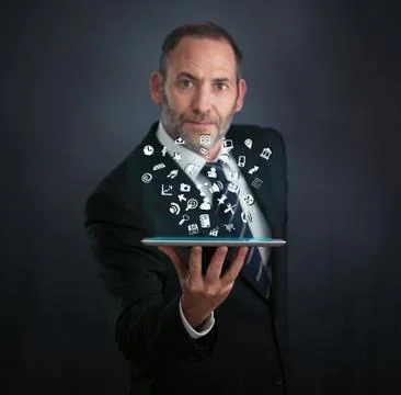 Tablet pc with cloud of application icons flying around Stock Photos