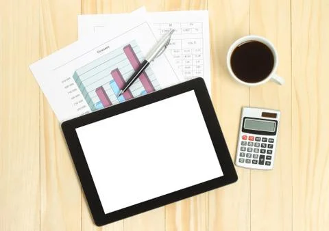 Tablet pc, cup of coffee and paper with graphs . Stock Photos
