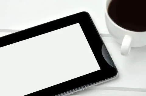 Tablet pc with cup of coffee on table Stock Photos