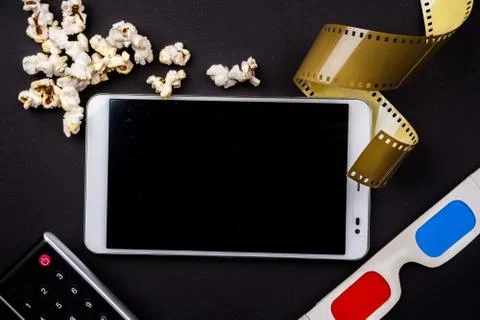 Tablet pc on dark background with attributes of cinema Stock Photos