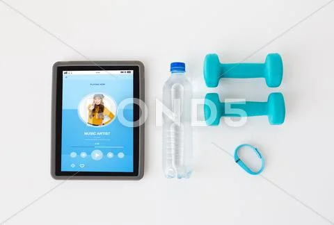 Tablet pc, dumbbells, fitness tracker and bottle Stock Photos