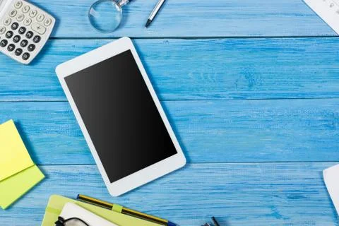 Tablet pc, empty blank screen on office table desk with set of colorful supplies Stock Photos