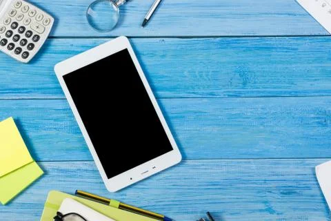 Tablet pc, empty blank screen on office table desk with set of colorful supplies Stock Photos