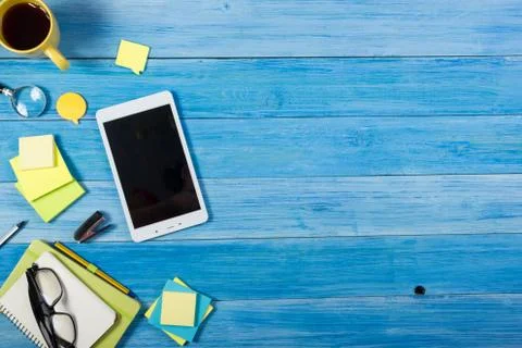 Tablet pc, empty blank screen on office table desk with set of colorful supplies Stock Photos