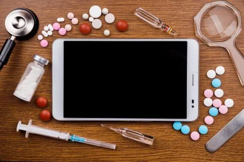 Tablet pc with medical objects on a desk as a metaphor for electronic diagnostic Stock Photos