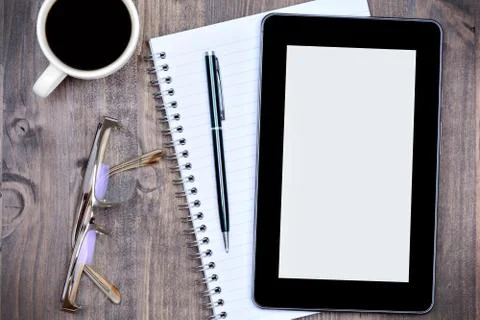 Tablet pc with notepad and coffee on wooden table Stock Photos