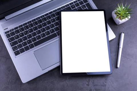 Tablet Pc over silver laptop on desktop Stock Photos
