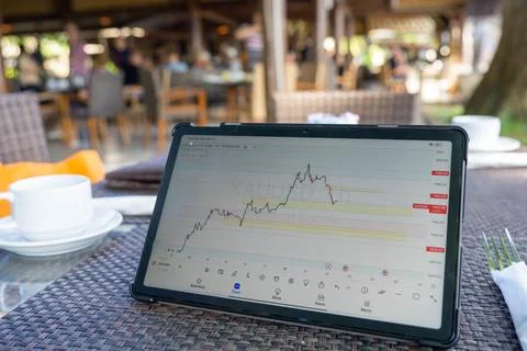 Tablet phone on the dining table. Trading foreign exchange anywhere Stock Photos