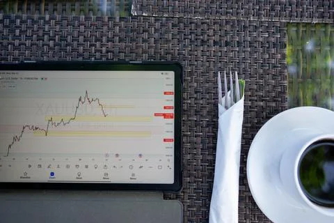 Tablet phone on the dining table. Trading foreign exchange anywhere Stock Photos