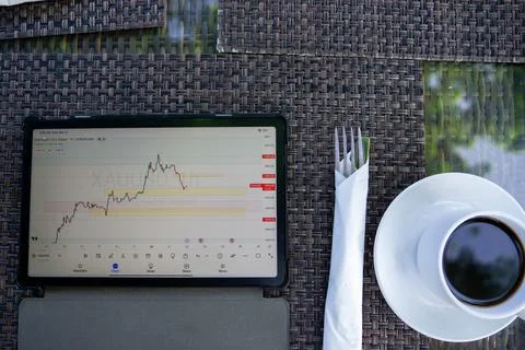 Tablet phone on the dining table. Trading foreign exchange anywhere Stock Photos