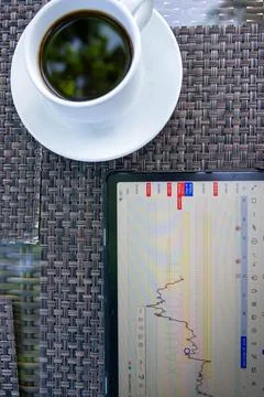 Tablet phone on the dining table. Trading foreign exchange anywhere Stock Photos