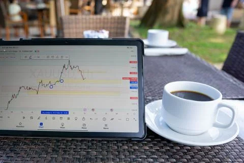 Tablet phone on the dining table. Trading foreign exchange anywhere Stock Photos