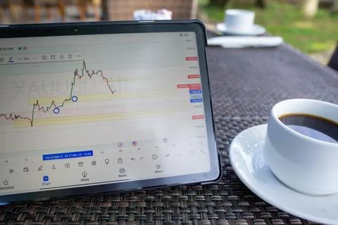 Tablet phone on the dining table. Trading foreign exchange anywhere Stock Photos