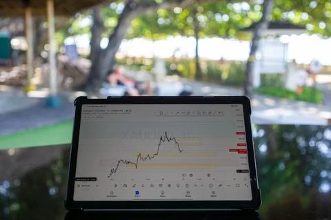Tablet phone on the dining table. Trading foreign exchange anywhere Stock Photos