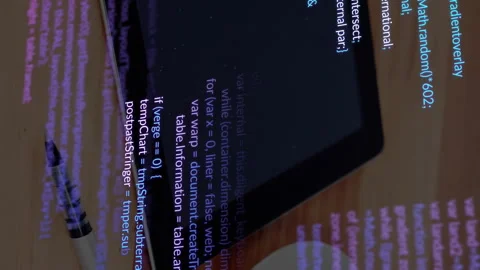 Tablet with programming code and pen on wooden desk, animation showing Stock Footage 313370340