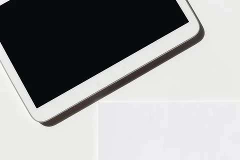 Tablet rests on a flat surface with a blank screen, showcasing its design and Stock Photos